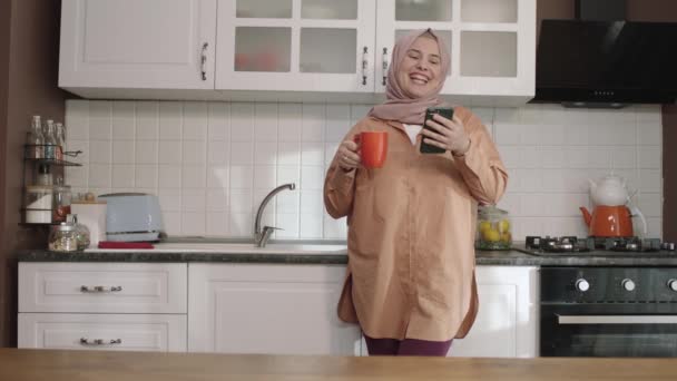 Uśmiechnięta Kobieta Patrząc Przepisy Podczas Picia Kawy Kuchni Młoda Kobieta — Wideo stockowe