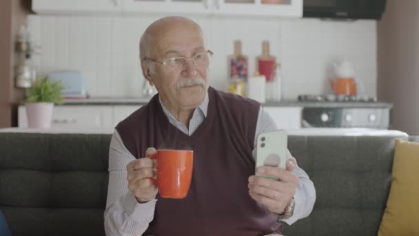 Homem Velho Passa Tempo Com Seu Smartphone Enquanto Bebe Café — Vídeo de Stock