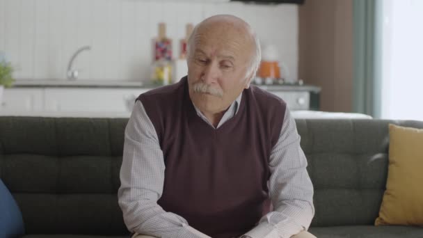 悲しい老人は過去の記憶を切望しています 放棄された男は不幸に苦しむ 自宅でソファに座っている思考落ち込んで孤独な男とうつ病精神衛生の概念 — ストック動画