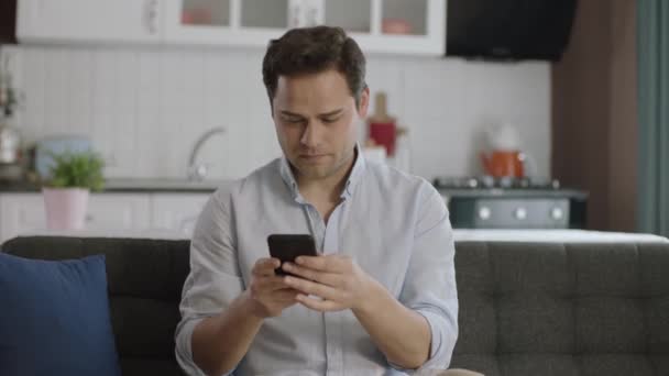 Hombre Joven Vestido Casual Usando Teléfono Inteligente Sofá Casa Hombre — Vídeo de stock
