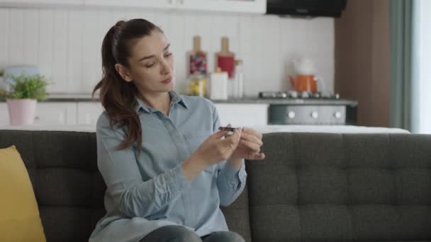 Jonge Vrouw Zittend Haar Sofa Thuis Snijden Haar Nagels Met — Stockvideo