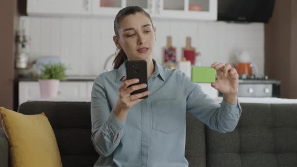 Kobieta Trzymająca Sofie Smartfon Zieloną Skrzynkę Pokazująca Produkt Uśmiechająca Się — Wideo stockowe