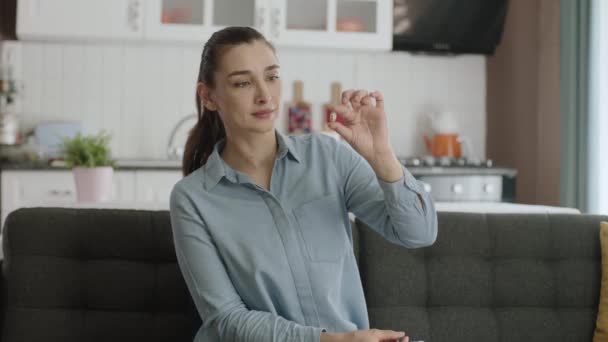 Mujer Joven Mostrando Píldora Mano Sofá Sala Estar Mujer Demuestra — Vídeos de Stock