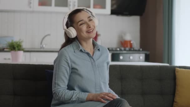 Jonge Vrolijke Vrouw Zit Stoel Luisterend Naar Muziek Met Koptelefoon — Stockvideo