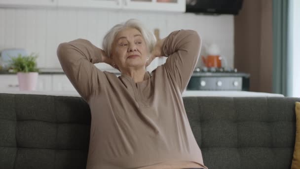 Спокійна Старенька Відпочиває Своєму Тихому Будинку Літня Жінка Сидить Дивані — стокове відео