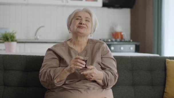 Szczęśliwa Staruszka Ogląda Zabawny Film Telewizji Pijąc Herbatę Starsza Kobieta — Wideo stockowe