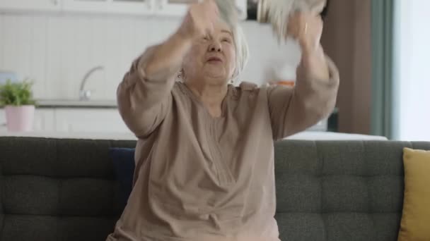 Щаслива Стара Збуджена Долари Стара Жінка Сидить Дивані Кидає Банкноти — стокове відео