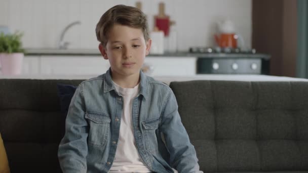 Μικρό Αγόρι Που Κάθεται Στον Καναπέ Του Σπιτιού Του Έννοια — Αρχείο Βίντεο