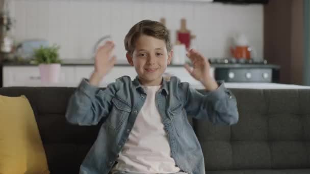 Mały Chłopiec Oklaskuje Sukces Siedząc Kanapie Domu Chłopiec Jest Bardzo — Wideo stockowe
