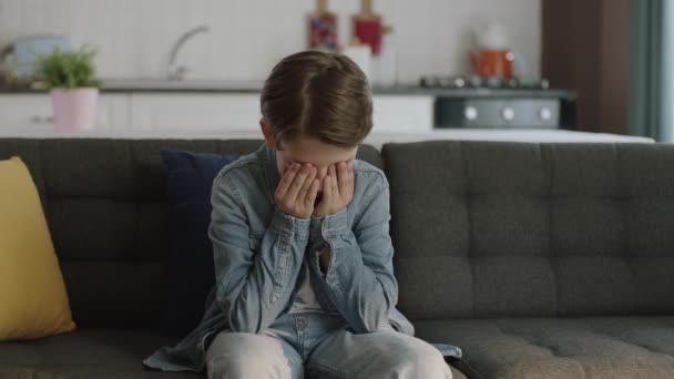 一个在家里闷闷不乐的悲伤焦虑的孩子的画像一个在家里独自咬手指的害怕的 无聊的 焦虑的孩子 他感到沮丧和悲伤 人与负面情绪概念 — 图库视频影像