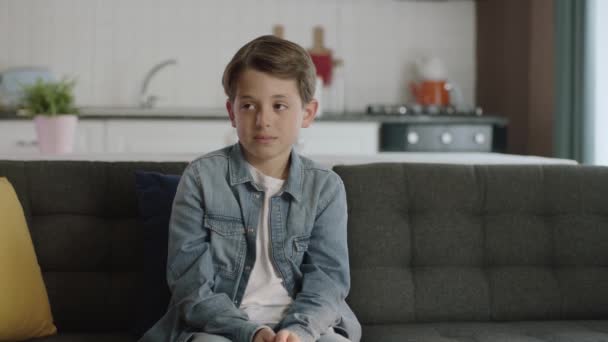 一个孤独而无聊的孩子在家里一个人坐在沙发上 感到沮丧而悲伤的慢动作肖像 人与负面情绪概念 — 图库视频影像