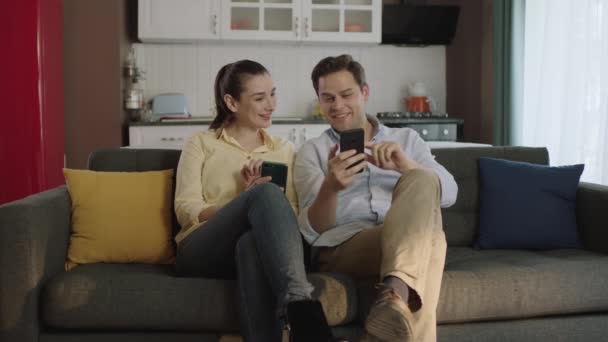 Šťastný Pár Mluví Smích Pohovce Při Pohledu Smartphone Pomocí Aplikací — Stock video