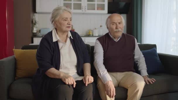 リビングルームでソファに座っている熟女カップル ちょうど戦いを持っていた老夫婦は 静かにお互いに話をせずに座っていました 高齢者の結婚における問題概念 — ストック動画