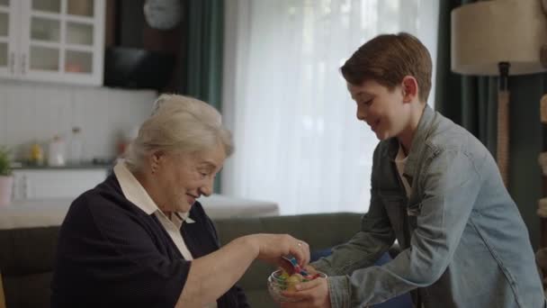 Chłopiec Oferuje Cukierki Misce Starszej Babci Mały Chłopiec Oferuje Cukierki — Wideo stockowe
