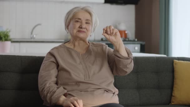 Seorang Wanita Tua Berambut Putih Menunjuk Pil Ruang Tamu Sofa — Stok Video