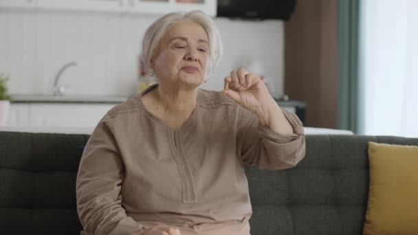 一位白发苍苍的老妇人指着客厅里的一片药丸 她指出手中的药是完美的 快乐的老妇人表现出医疗保健 疾病治疗 维生素 — 图库视频影像