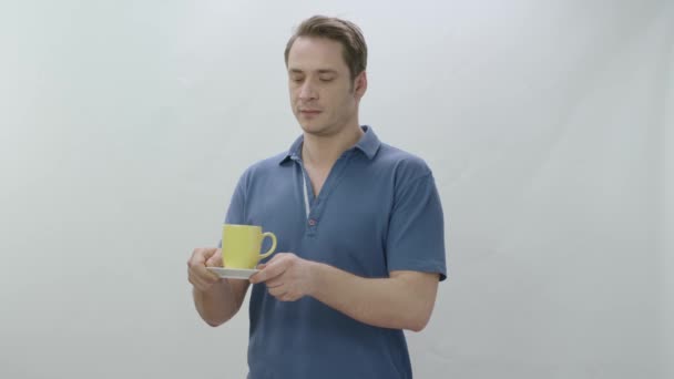 Молодой Человек Держит Чашку Чая Кофе Крытая Студия Изолирована Белом — стоковое видео