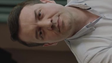 Character portrait of serious looking man in kitchen. Young man in casual clothes looking at camera seriously and nervously. Portrait of a 40-year-old white man.Vertical video.