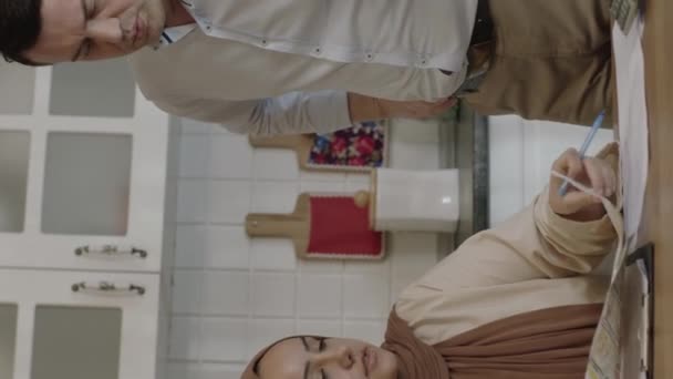 Мусульманська Молода Пара Перевіряє Платежі Вдома Кухні Вони Керують Сімейним — стокове відео