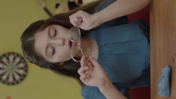 Uma Estudante Entediada Limpar Óculos Numa Mesa Casa Uma Criança — Vídeo de Stock