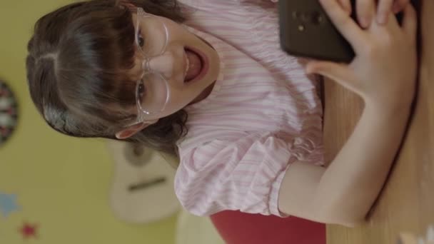 스마트폰으로 온라인 게임을 하면서 새로운 기술을 사용하는 귀여운 소녀입니다 아이가 — 비디오