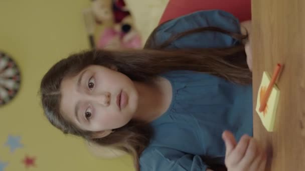 Domu Dziewczynka Siedzi Przy Stole Rozmawia Pustą Przestrzenią Reklamową Prawej — Wideo stockowe