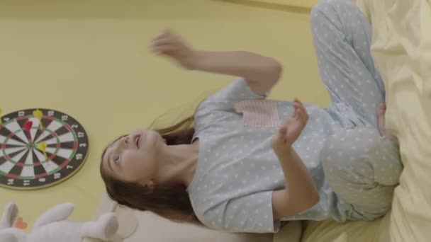 Menina Sentada Sua Cama Seu Pijama Está Divertindo Jogando Brinquedo — Vídeo de Stock