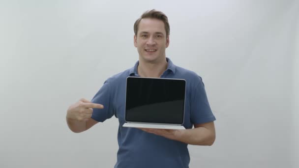 태블릿 컴퓨터 가리키며 손가락을 내밀고 배경에 태블릿 컴퓨터를 고립된 젊은이 — 비디오