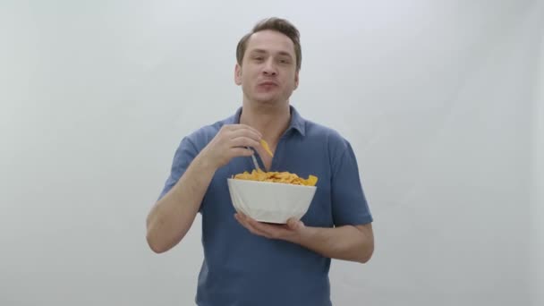 Ένας Νεαρός Τρώει Πικάντικα Τσιπς Σνακ Έννοια Πρόχειρο Φαγητό Λευκό — Αρχείο Βίντεο