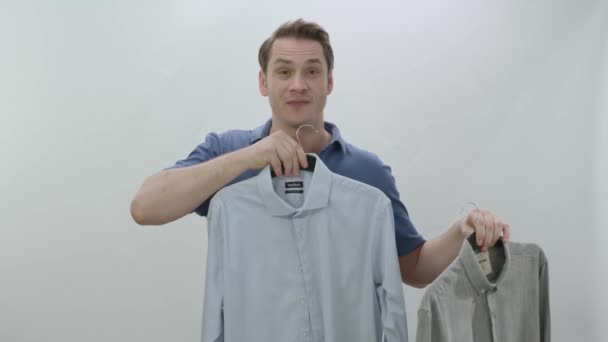 Junger Mann Isoliert Vor Weißem Hintergrund Mit Zwei Hemden Der — Stockvideo
