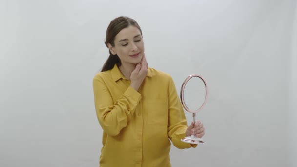 Küçük Bir Ayna Tutan Cildini Saçlarını Kontrol Eden Bir Kadın — Stok video