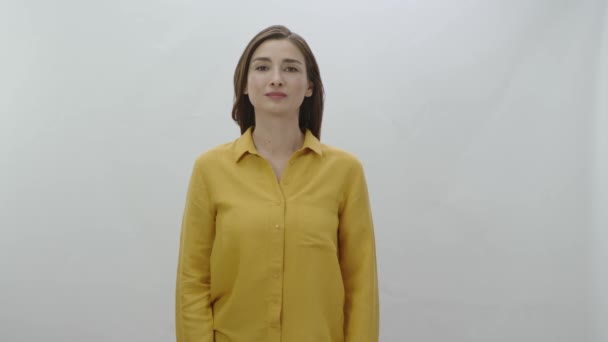 Kadın Düşünceli Bir Şekilde Kameraya Bakıyor Stüdyoda Beyaz Bir Arkaplanda — Stok video