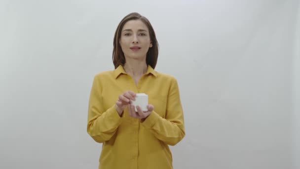 Jonge Vrouw Geïsoleerd Witte Achtergrond Met Doos Van Gezicht Huidcrème — Stockvideo