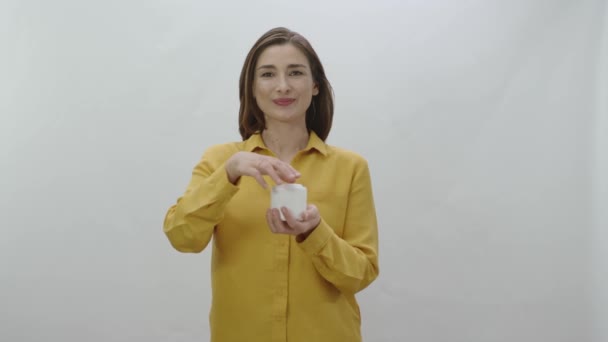 Mujer Joven Aislada Sobre Fondo Blanco Sosteniendo Caja Crema Facial — Vídeos de Stock