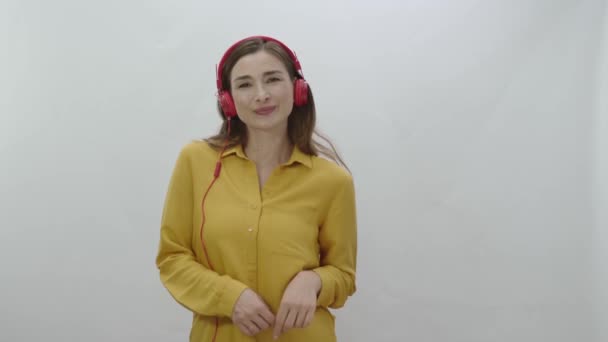 Beyaz Arka Planda Kulaklıkla Şarkı Söyleyen Bir Kadın Dans Eden — Stok video