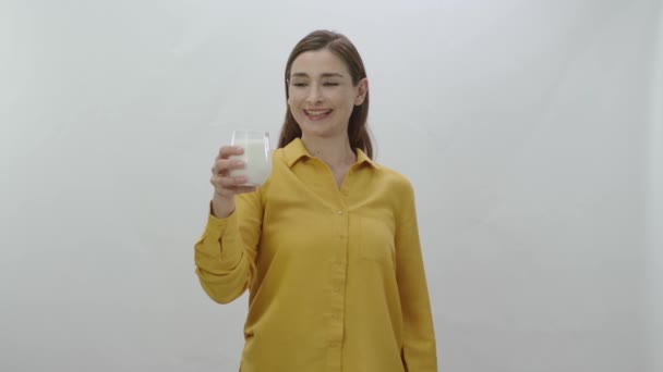 ミルクを飲みながら強い二足歩行を見せる若い女性のキャラクターポートレート 牛乳を飲むことで強いと言う女 白地に隔離された — ストック動画