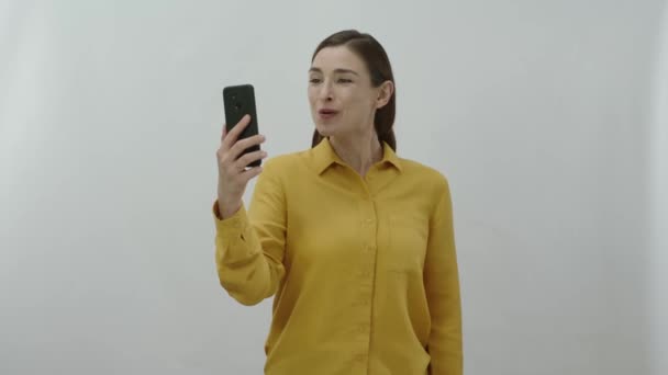 Urocza Młoda Kobieta Pokazuje Smartfon Zielonym Ekranem Stojąc Odosobnionym Tle — Wideo stockowe