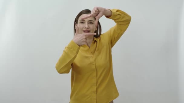 Kobieta Odizolowana Białym Tle Oprawiająca Kamerę Patrzy Kamerę Robi Ramę — Wideo stockowe