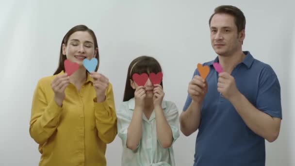 Feliz Familia Sonriente Sosteniendo Corazón Papel Sus Ojos Aislados Sobre — Vídeo de stock