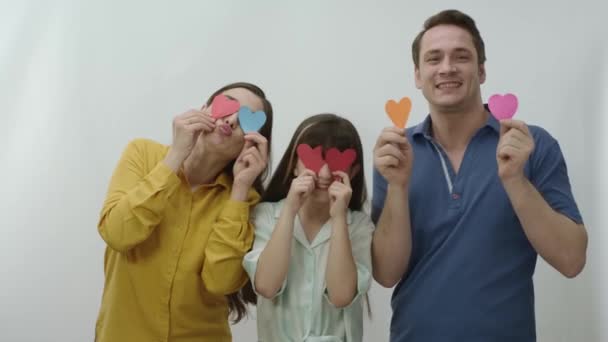 Feliz Família Sorridente Segurando Coração Papel Seus Olhos Isolados Fundo — Vídeo de Stock