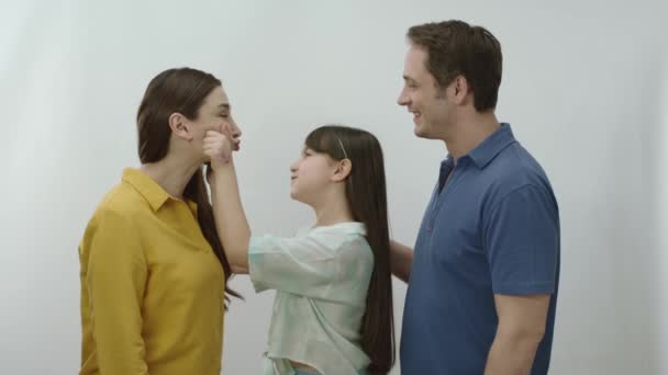 Szczęśliwa Rodzina Białym Tle Mała Dziewczynka Pokazuje Rodzicom Miłość Szczypiąc — Wideo stockowe