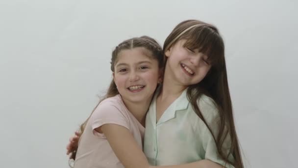 Retrato Dos Niñas Hermosas Sobre Fondo Blanco Lindas Niñas Abrazándose — Vídeos de Stock