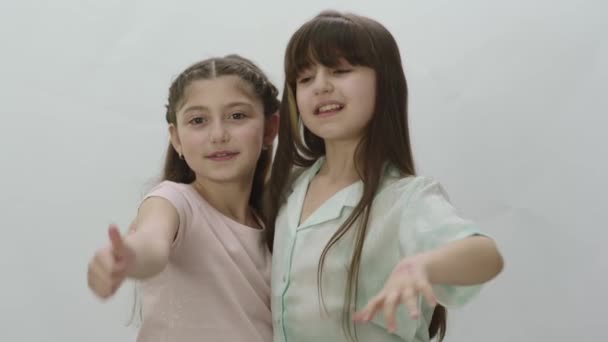 Πορτρέτο Δύο Όμορφων Μικρών Κοριτσιών Λευκό Φόντο Χαριτωμένα Κοριτσάκια Αγκαλιάζονται — Αρχείο Βίντεο
