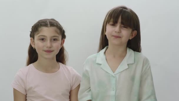 Porträt Zweier Hübscher Kleiner Mädchen Auf Weißem Hintergrund Nette Kleine — Stockvideo