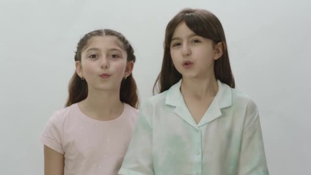 Retrato Duas Meninas Bonitas Fundo Branco Miúdas Giras Mandar Beijos — Vídeo de Stock