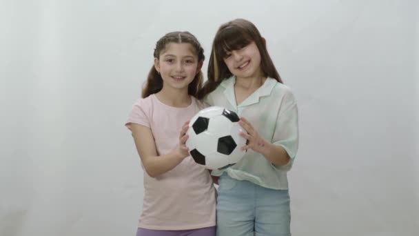 兴奋的小女孩正在考虑长大后成为足球运动员 女孩们拿着一个足球 鼓励幼儿参加体育活动的概念 — 图库视频影像