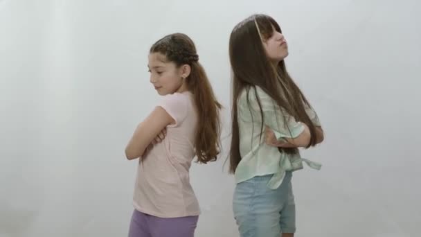 白を背景に二人の少女が喧嘩している 女の子はお互いに戻るには 戦いの後に話をしないでスタンド嫌い 小さな子供たちが戦ってる — ストック動画
