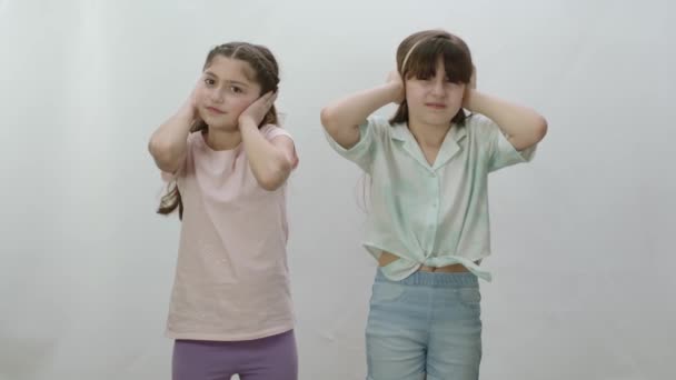 Két Lány Egymás Mellett Áll Egy Fehér Háttérben Kis Tehetetlen — Stock videók