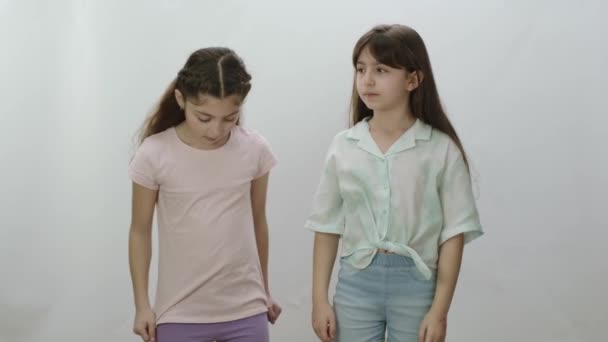 Dos Chicas Paran Una Lado Otra Aisladas Sobre Fondo Blanco — Vídeo de stock