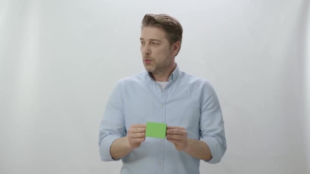 白い背景に孤立した若い男のスタジオの肖像画 緑色の箱を持っている人はプロダクトが優れている示す クリエイティブ3Dアーティストは 緑のボックスを任意の製品に置き換えることができます — ストック動画